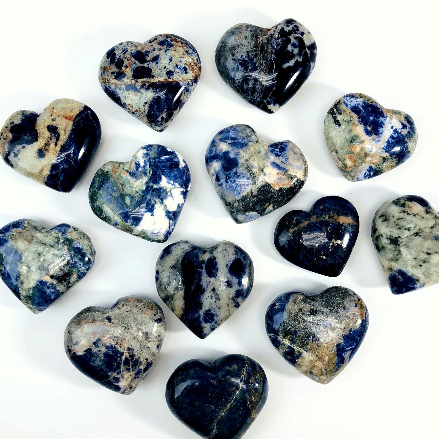 overhead view of many sodalite heart shaped stones on white background for possible variations