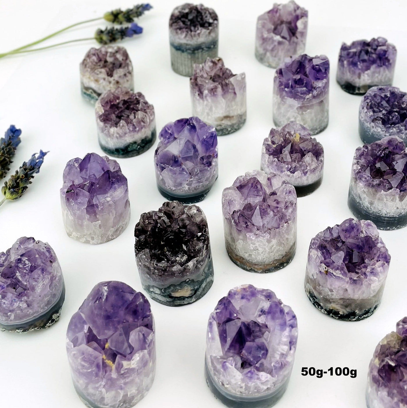 A variety of size 50gram - 100gram amethyst cores on a white background.