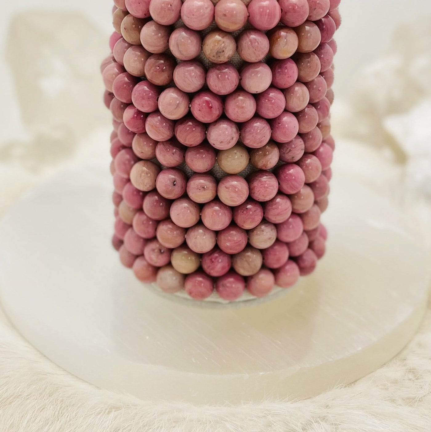 rhodonite bracelets stacked on a stand