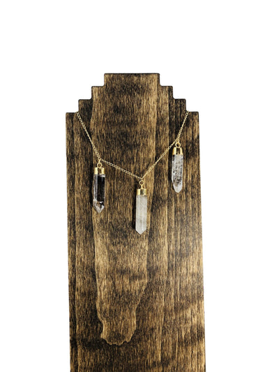 triple point necklace displayed on wooden stand