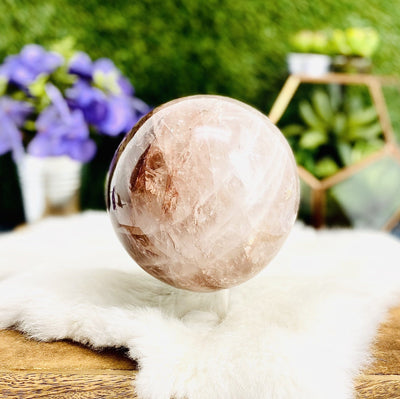 Hematoid Quartz Polished Sphere with decorations in the background