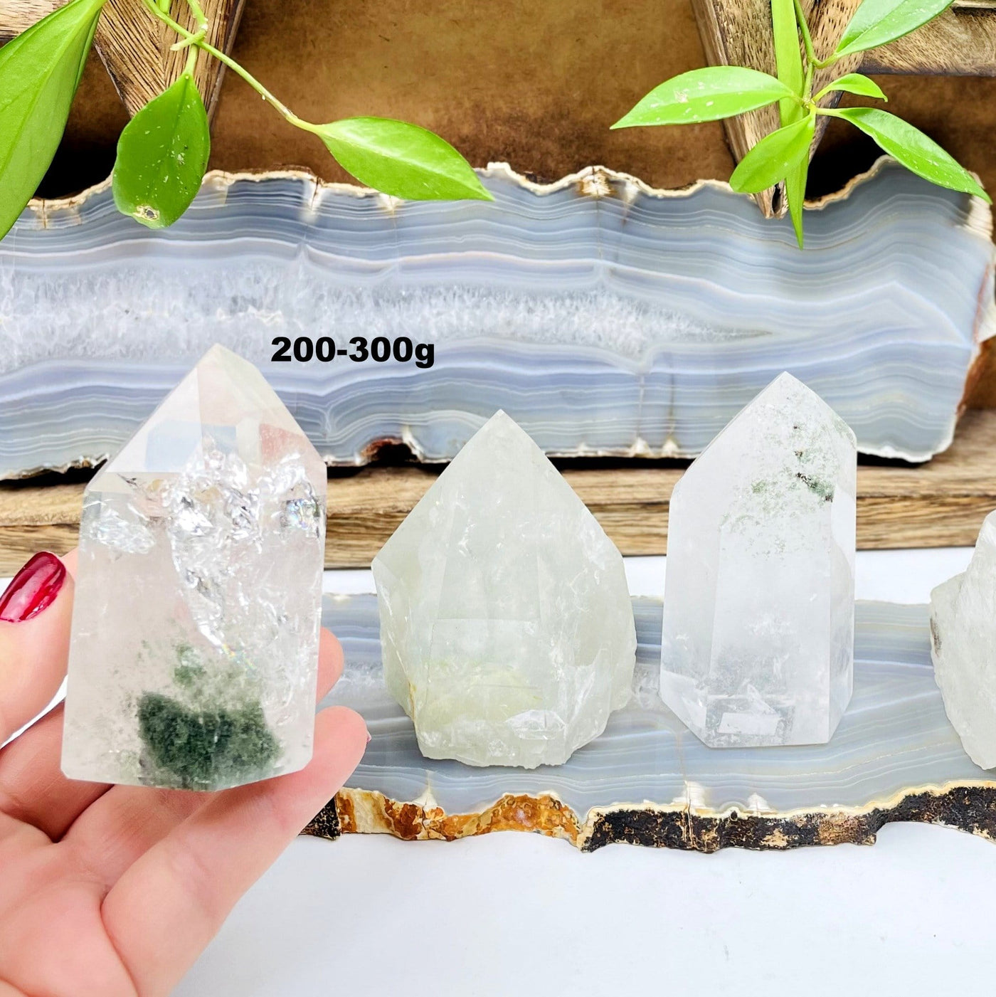 200-300g semi-polished quartz with chlorite point in hand for size reference with others on display