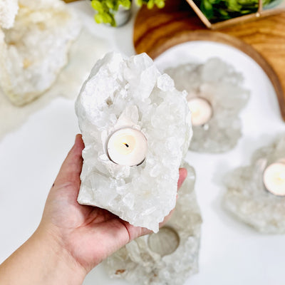 Crystal Quartz Cluster Candle Holder with a candle in it in a hand