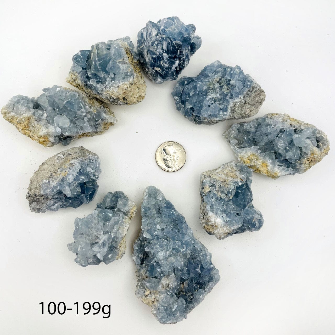 Celestite Crystals in size 100-199g next to a quarter for size reference