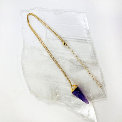 Amethyst Pendulum necklace on a cystal slab