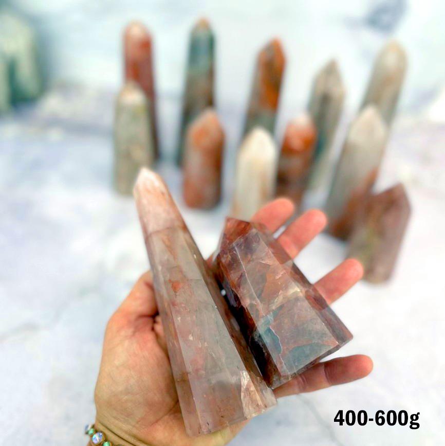 Hematoid Quartz Polished Towers 400-600g displayed in hand for size reference