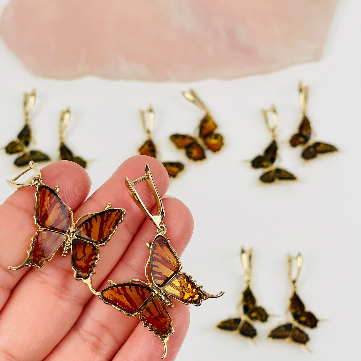 butterfly shaped amber lined with 24k gold in hand for size reference 
