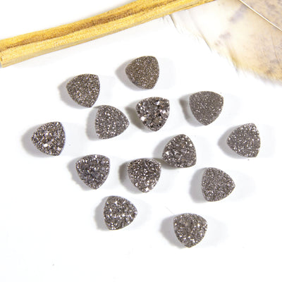 multiple platinum triangle druzy cabochons displayed on white background