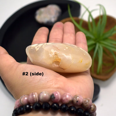 hand holding up Flower Agate Polished Stone Heartshwoing side view