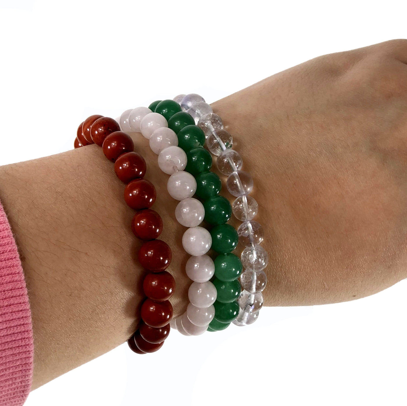 varied healing stone bracelets being worn with white background