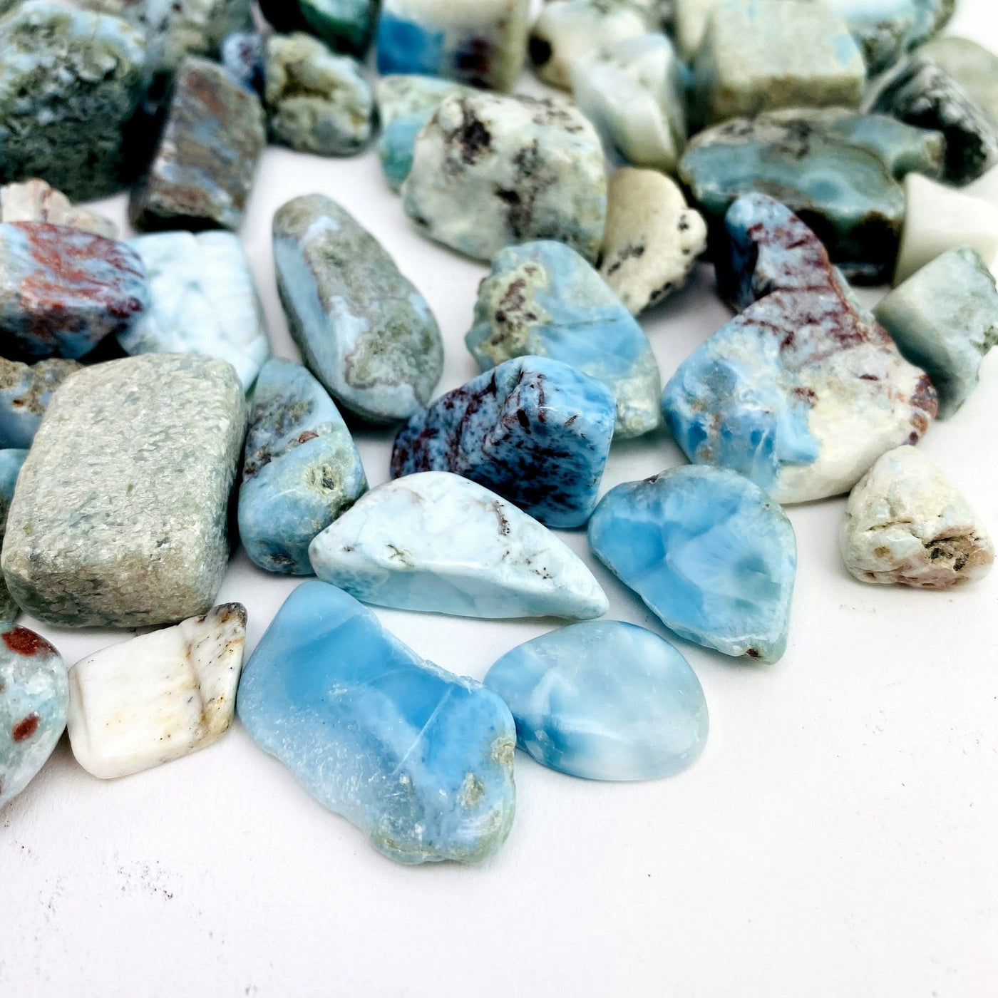 side view of larimar tumbled stones for thickness reference