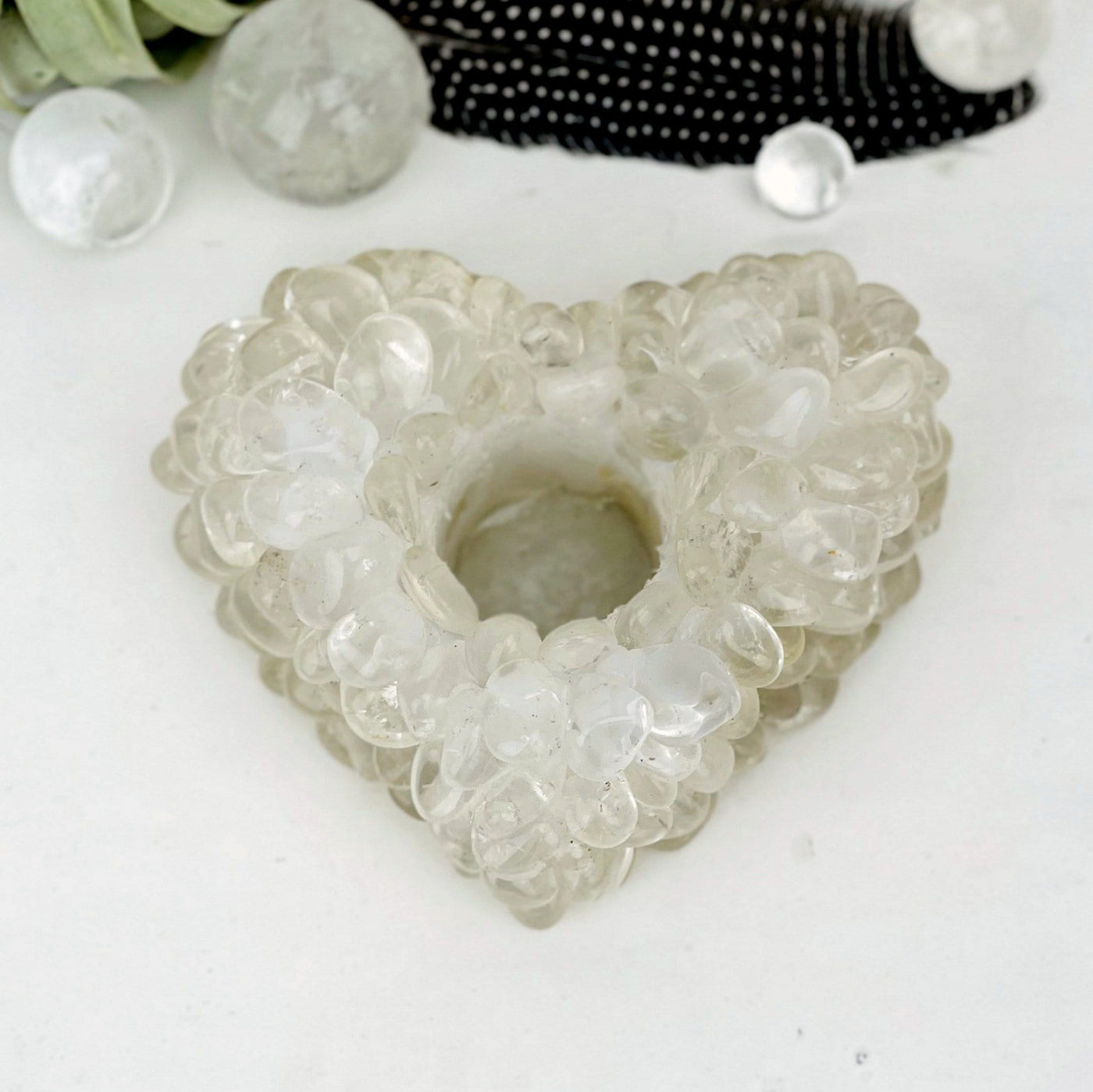 Heart shaped candle holder that is made with crystal quartz tumbled stones that are glued together.