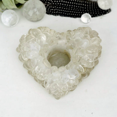 Heart shaped candle holder that is made with crystal quartz tumbled stones that are glued together.