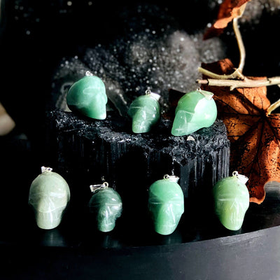 many aventurine skull shaped pendants on display for possible variations