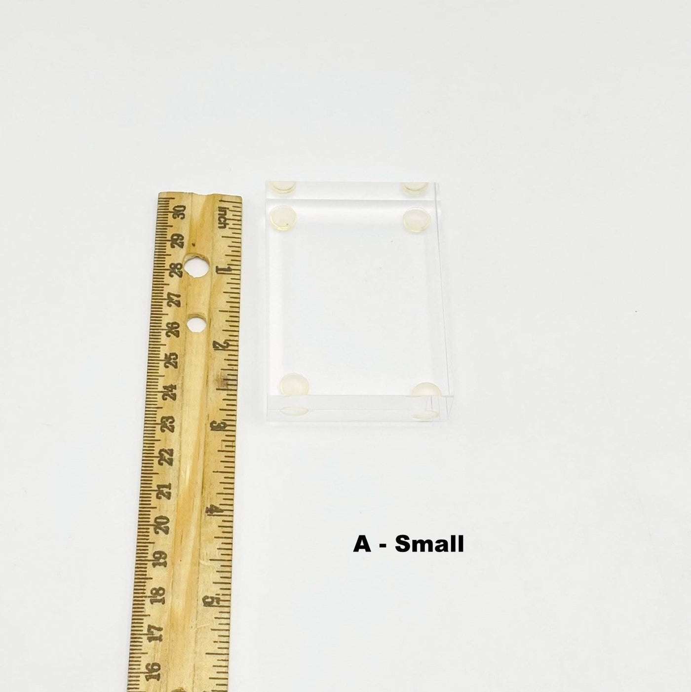 small thick acrylic crystal display stand next to a ruler for size reference