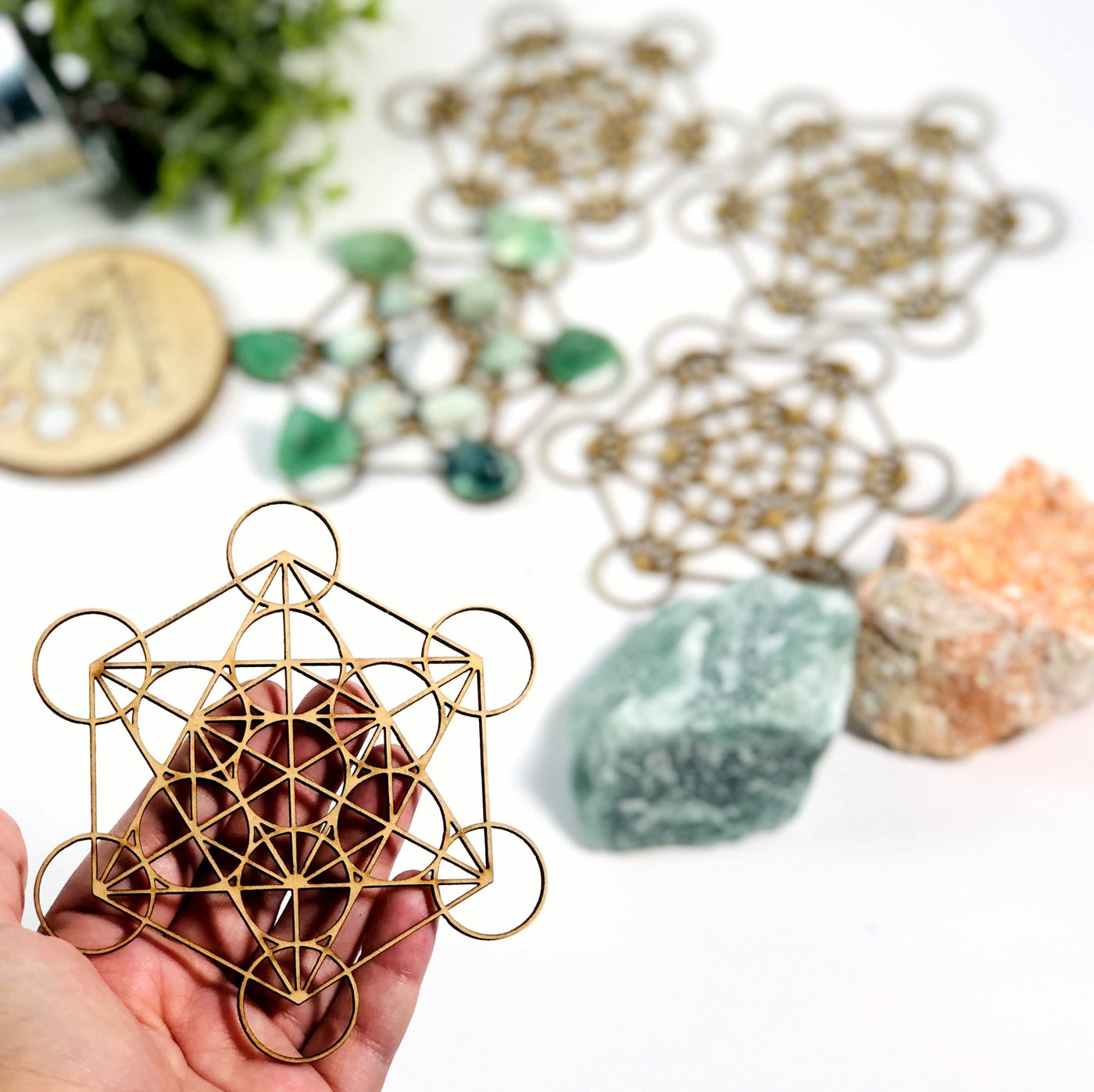 hand holding up metatron crystal grid with others blurred in the background with decorations