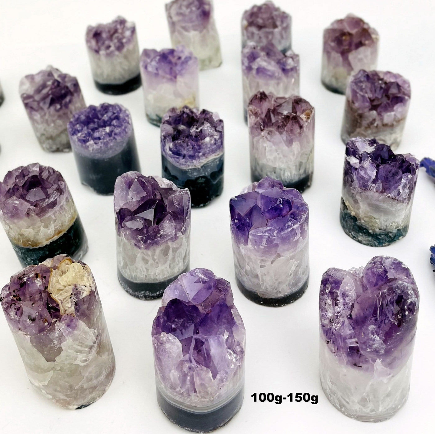 A variety of size 100gram - 150gram amethyst cores on a white background.