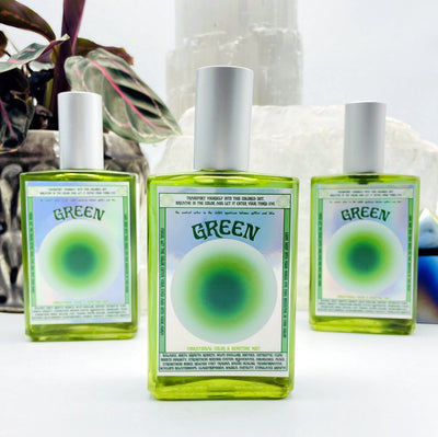 3 bottles of Gemstone Mist - Green Vibrational Color with decorations in the background