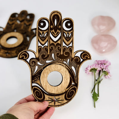 one hamsa hand wooden sphere stand pictured in hand to show size reference on white background