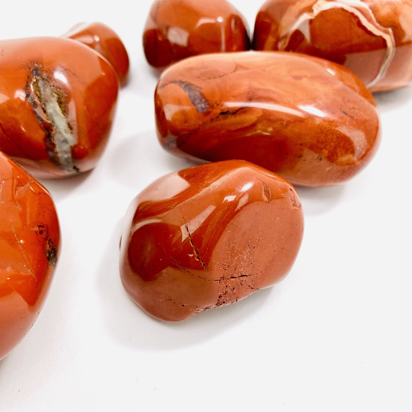 Up close shot of 2 Red Jasper tumbled Stones with others in the background