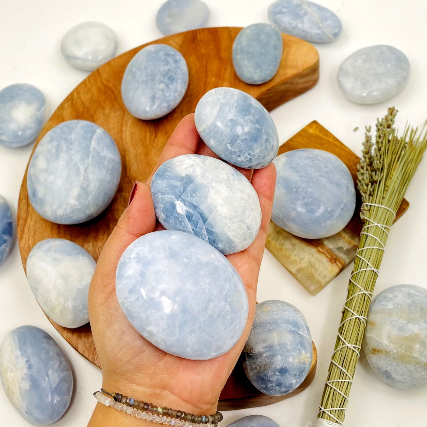 blue calcite palm stones in a hand