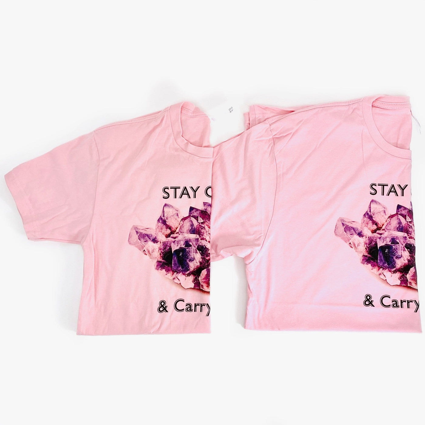 different sized Stay Calm and Carry One t shirts in pink