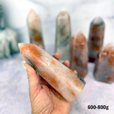 Hematoid Quartz Polished Towers 600-800g displayed in hand for size reference