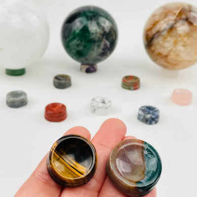 crystal sphere holders in hand for size reference 
