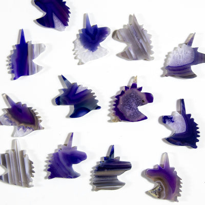 Purple agate unicorn heads being displayed on a white background.