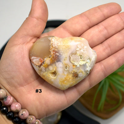 hand holding up Flower Agate Polished Stone Heart