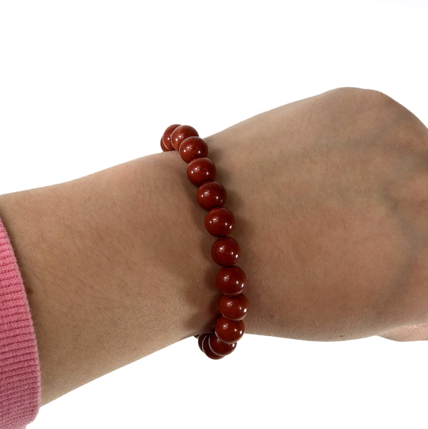 red jasper healing stone bracelet being worn with white background