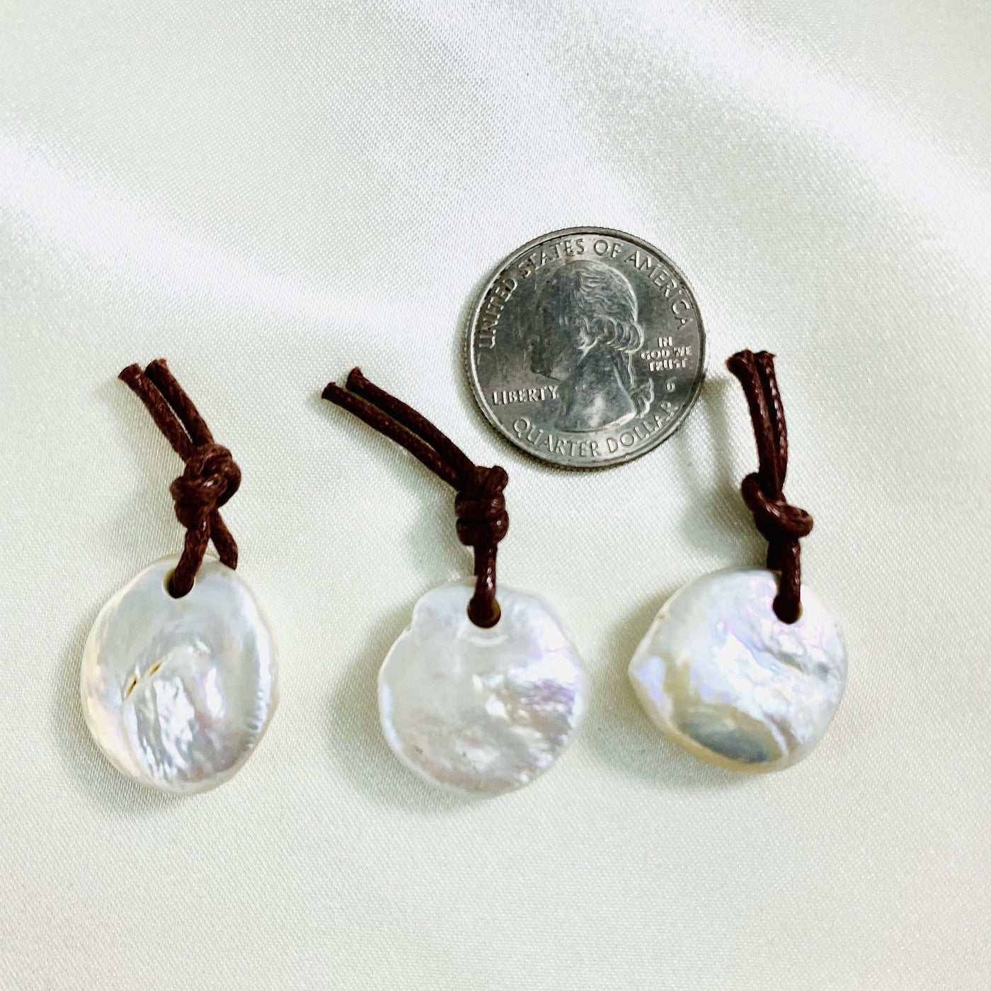 Mother of Pearl Round Pendants - 3 next to a quarter
