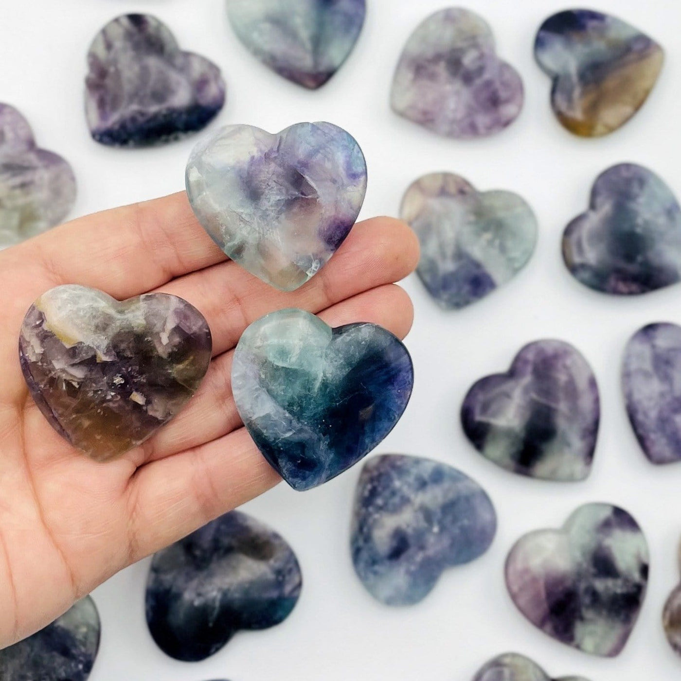 Fluorite Hearts displayed in hand for size reference