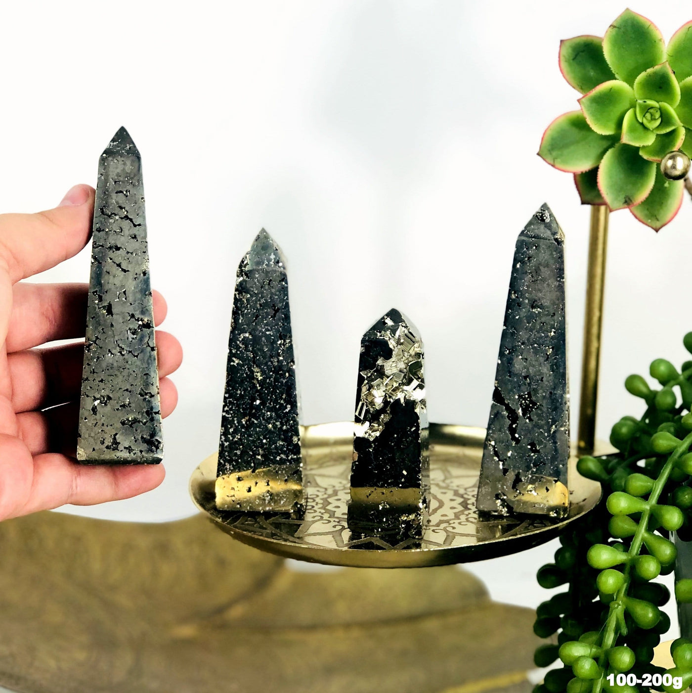 4 assorted pyrite obelisk towers on a gold background