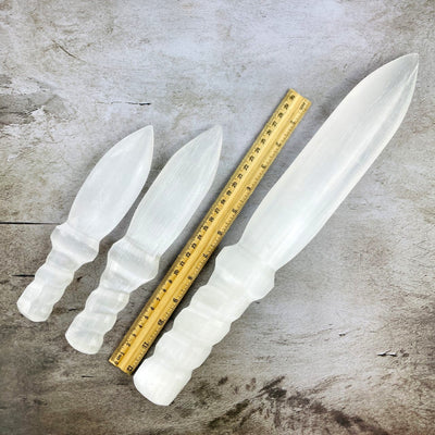 3 sizes of Selenite Knife with Twisted Handles next to a ruler to show size
