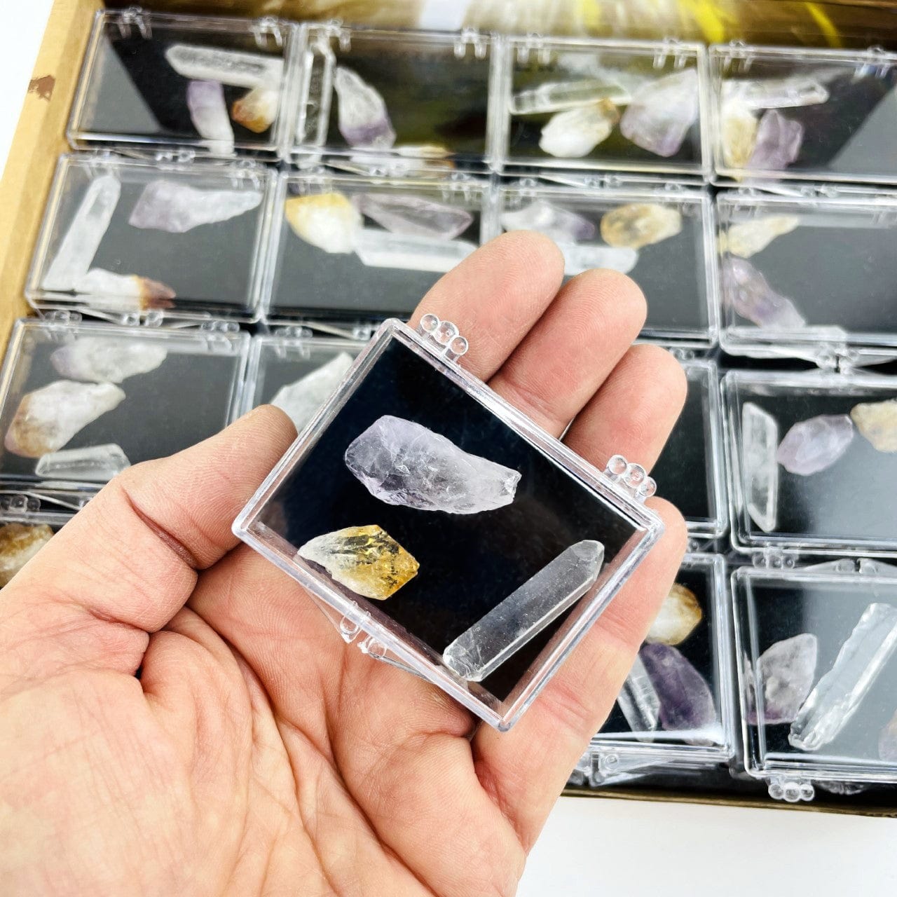 Natural Mineral Points - Box of Crystals with an amethyts, crystal point and a citrine point in a hand for size reference