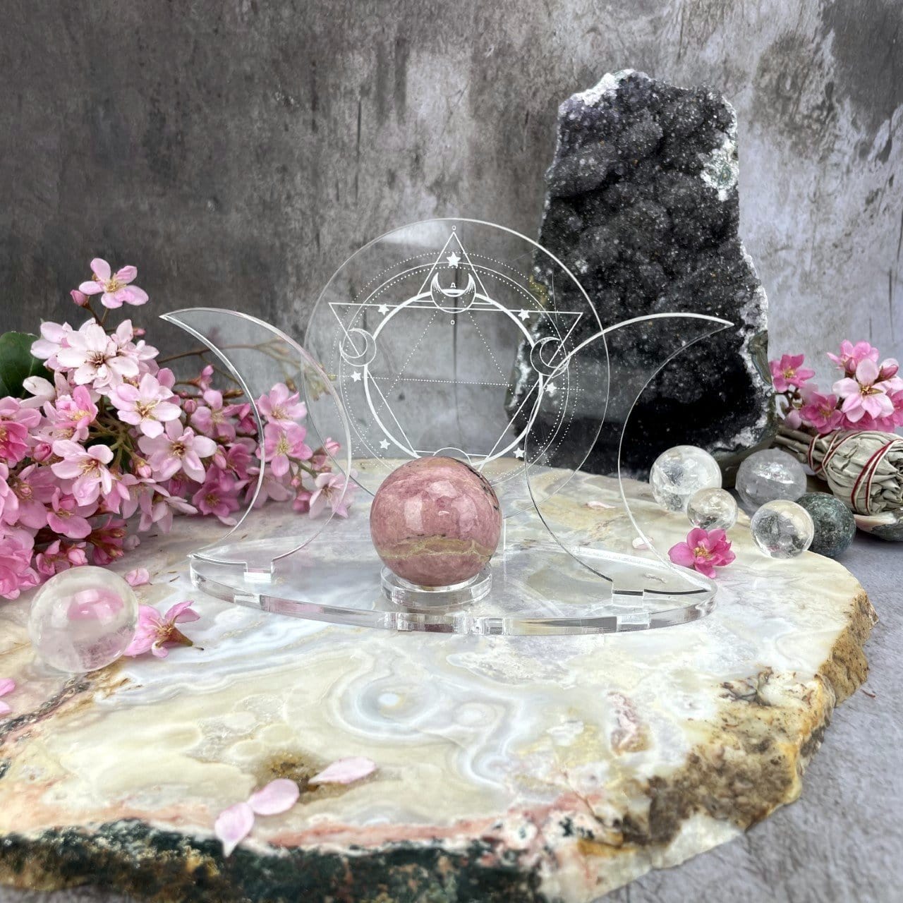 Acrylic Sphere Holder Crescent Moons - Six Pointed Star in an alter holding a sphere surrounded with crystals and flowers for display.