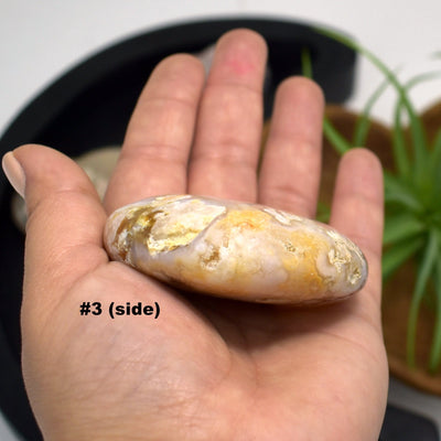 hand holding up Flower Agate Polished Stone Heart showing side view