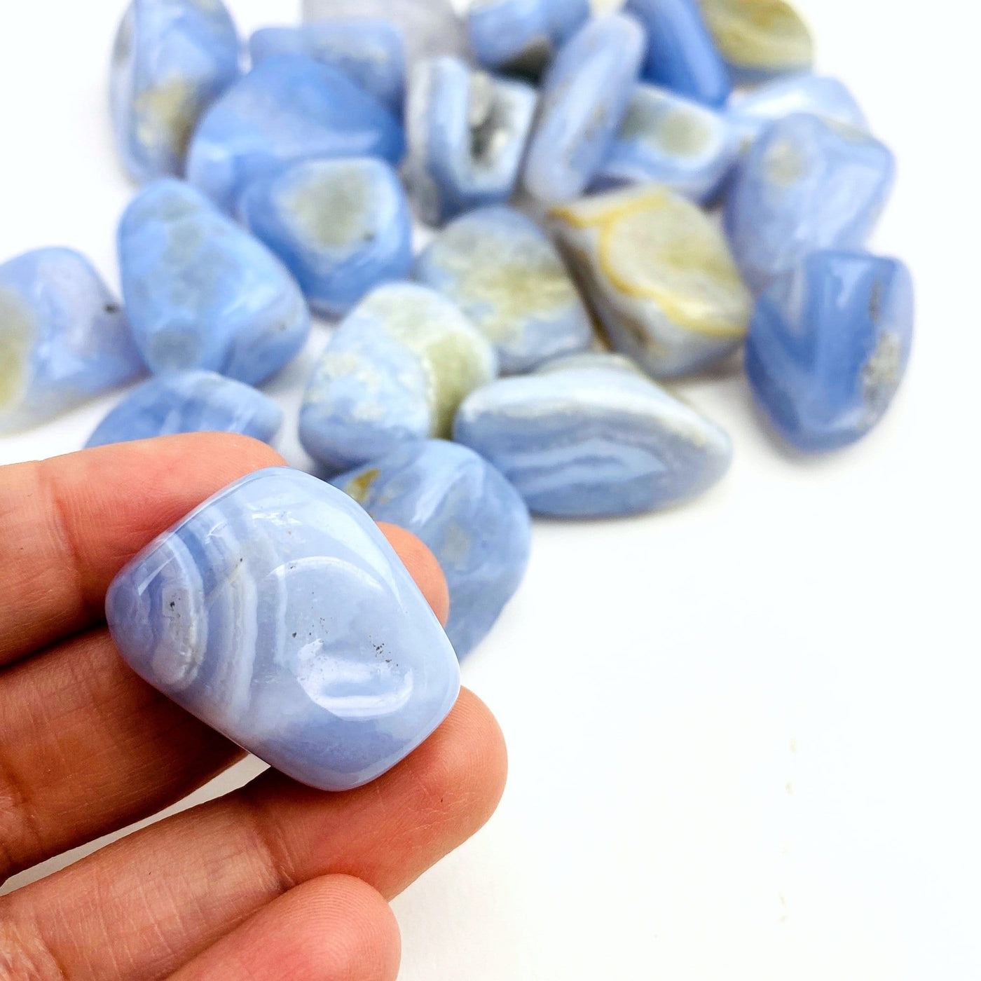 Blue Lace Agate Medium Tumbled Stones with 1 in a hand for size reference