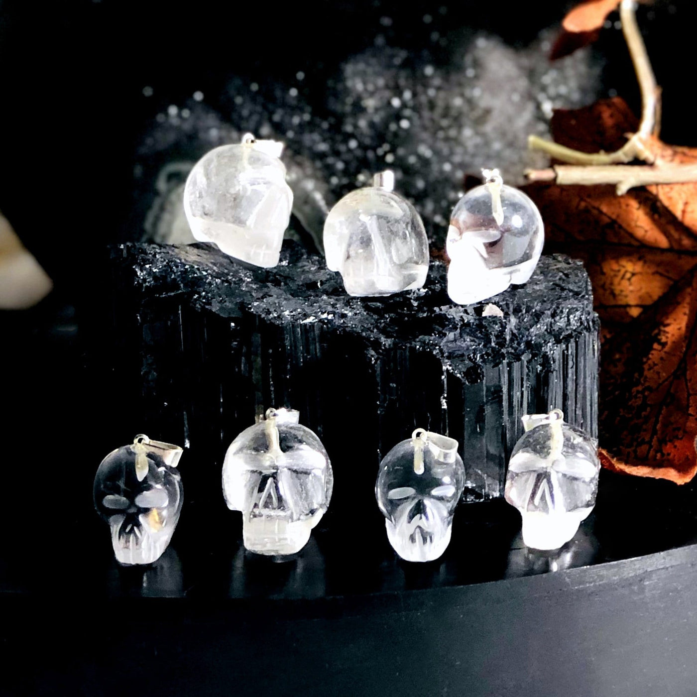 many crystal quartz skull shaped pendants on display for possible variations