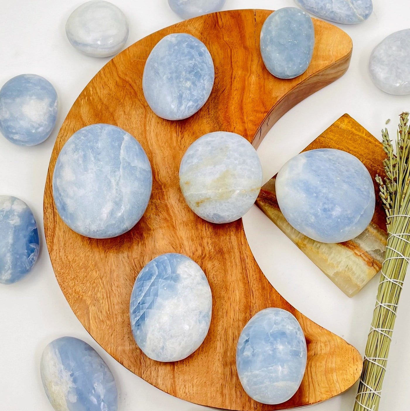 a bunch of blue calcite palm stones on and around a crescent