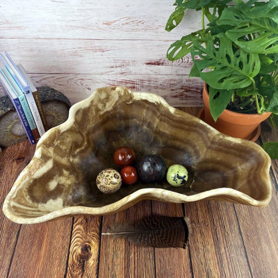 Mexican Onyx Bowl with crystals in it and decorations in the background