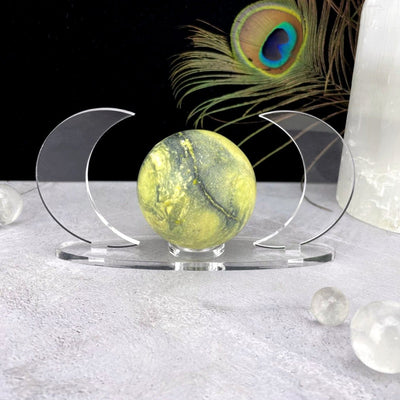 A front view of Acrylic Sphere Holder Crescent Moons - Clear Base holding a sphere in an alter.