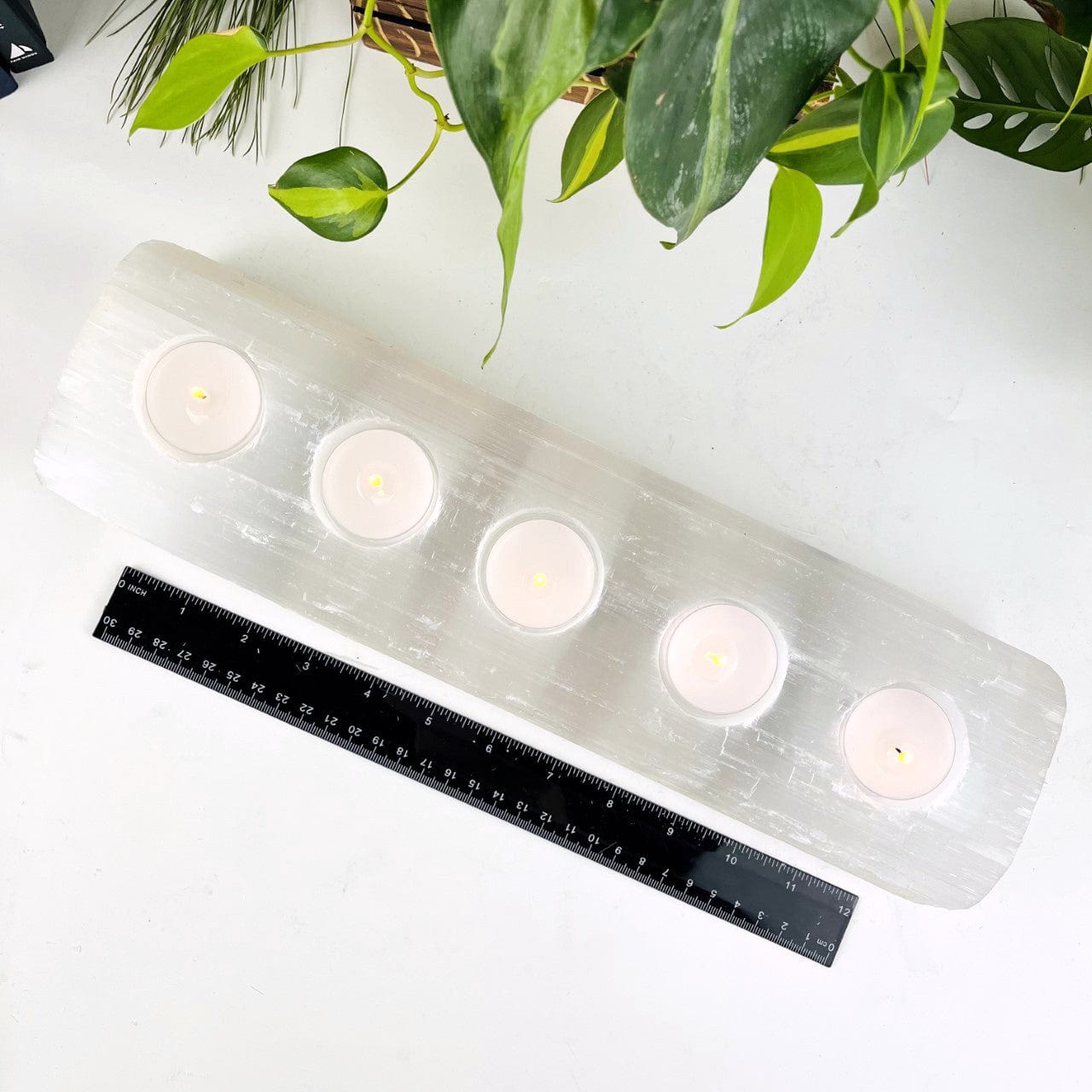 Selenite Candle Holder XL Size with 5 Holes for Votives Lit on display shown with a ruler