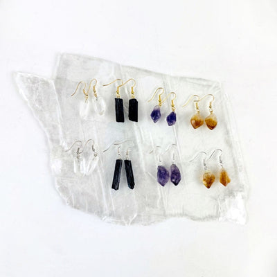All earrings in gold and silver plated on a selenite slab background.