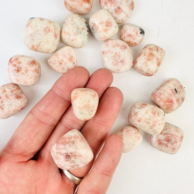 Tumbled Polished Sunstone Stone - 1/2 lb bag in a hand for size reference