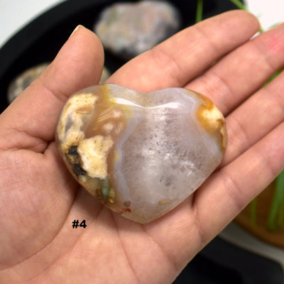 hand holding up Flower Agate Polished Stone Heart