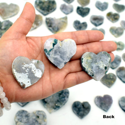 hand holding 3 Amethyst Flower Hearts showing backs of them
