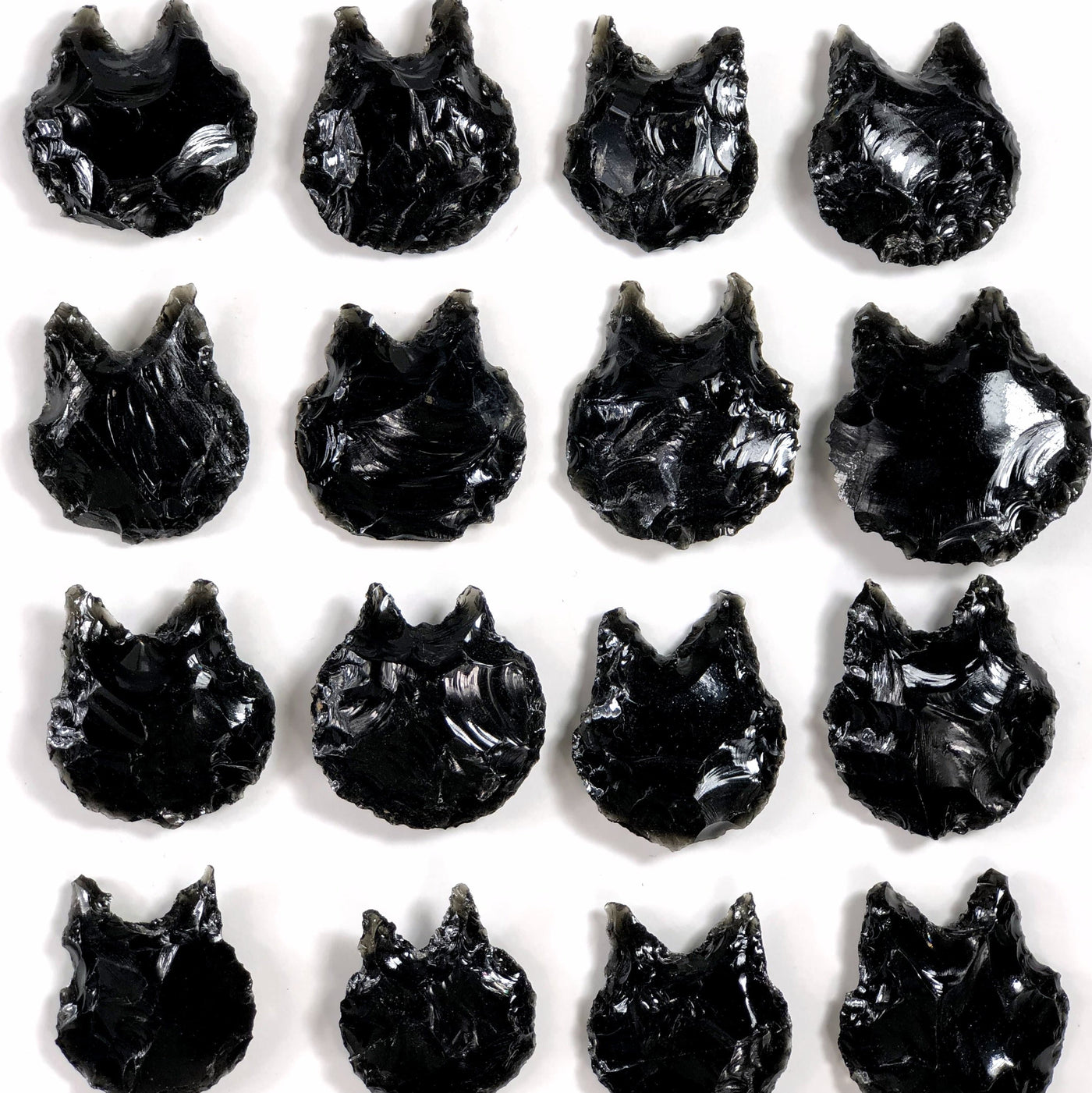 16 obsidian cats laid out on a white background