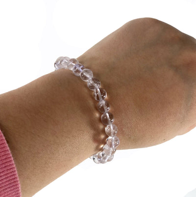 crystal quartz healing stone bracelet being worn with white background